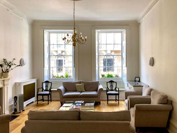 High ceiling patient waiting lounge with period chandelier and sash windows