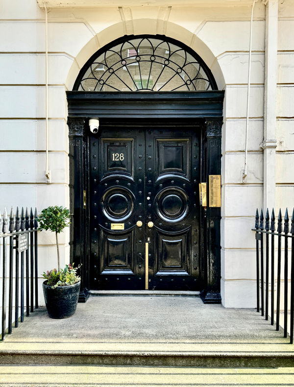 Iconic black Georgian front entrance door at 128 Harley Street Dental Clinic